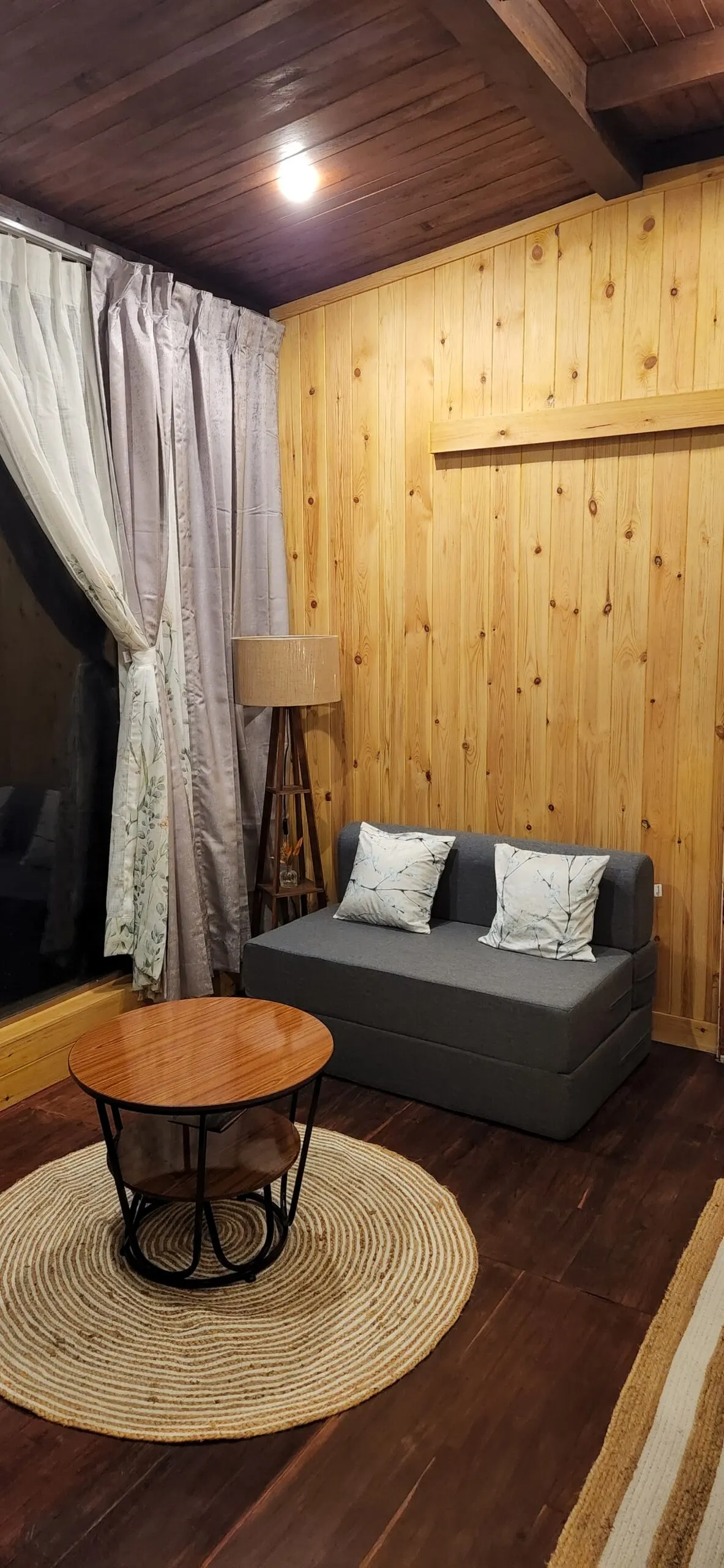 A sitting nook in the Machan — sofa, lamp, and a low table